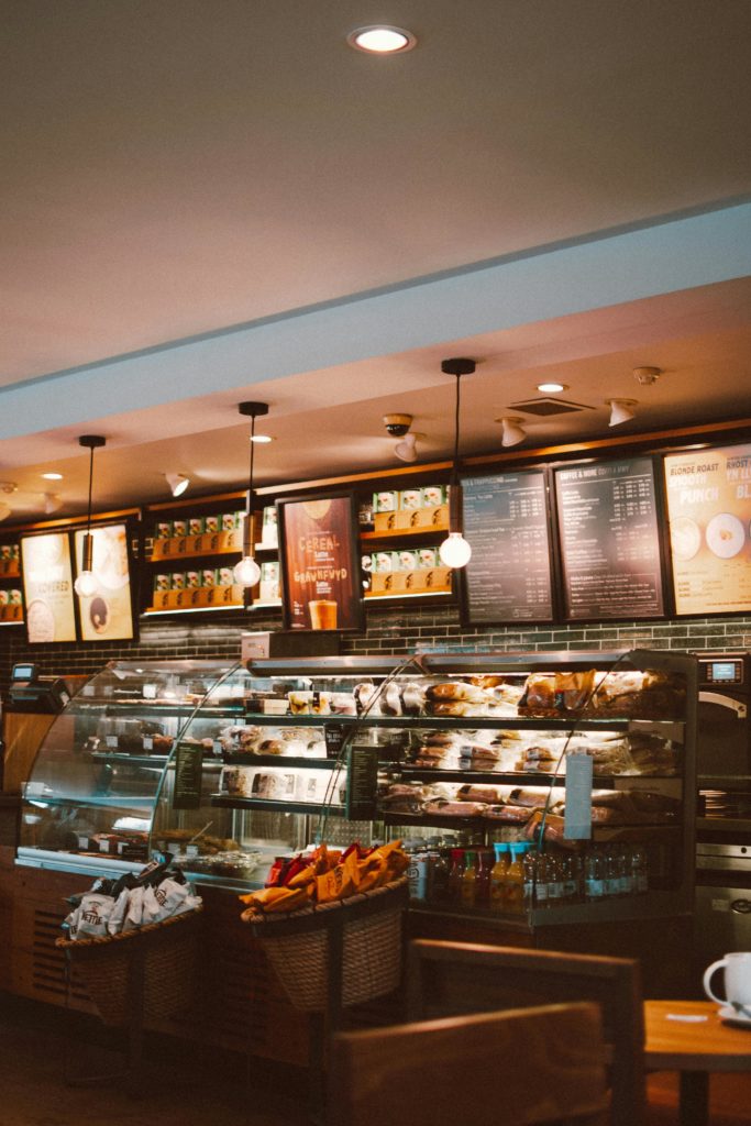 Warm and inviting café interior with a modern design, featuring a well-stocked counter and stylish lighting.